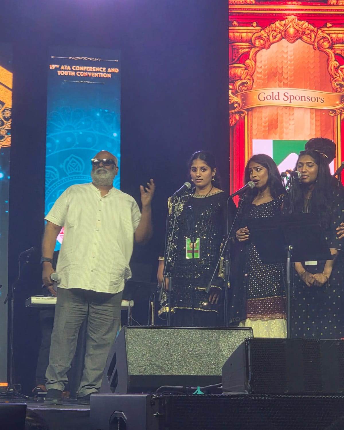 Hasitha on stage with the ensemble, M. M. Keeravani addressing the hall beside them.